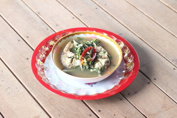Boiled tilapia in a bowl on wooden table