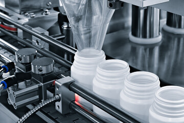 pharmaceutical industry, medicine pills are filling in the  bottle on production line machine conveyor at the medical factory. selective focus.