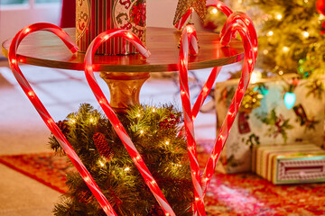 Illuminated candy cane decorations with evergreen wreath create festive Christmas holiday centerpiece display