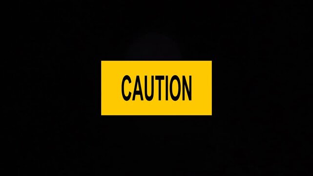 Un primer plano de un rect&aacute;ngulo de color amarillo con la palabra precauci&oacute;n y una luz blanca en movimiento en un fondo negro