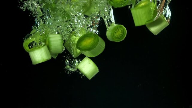 Sliced leeks fall under water. Filmed on a high-speed camera at 1000 fps. High quality FullHD footage