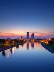Fototapeta premium City Skyline Reflects in River During Blue Hour With Twilight Sky Providing Space for Text Above
