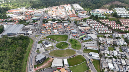 Imagem a&eacute;rea do horizonte de Mogi das Cruzes, no Alto Tiet&ecirc;, com pr&eacute;dios em meio a &aacute;reas verdes, representando urbaniza&ccedil;&atilde;o, desenvolvimento regional e integra&ccedil;&atilde;o com a natureza.