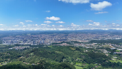 Obraz premium Visão aérea panorâmica de Mogi das Cruzes no Alto Tietê, mostrando extensa área urbana, bairros residenciais, áreas verdes e crescimento da cidade no interior de São Paulo