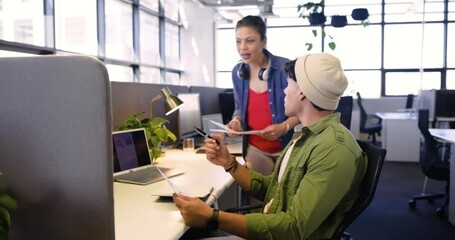 Receiving printout, diverse coworkers at desk studying graphs and pointing at monitors for analysis - Powered by Adobe