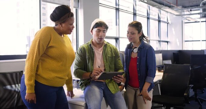 Diverse coworkers launching design app on tablet, annotating mockups and refining layout at office