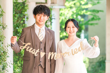 Bride and groom holding a garland at a wedding venue (bridal wedding)
