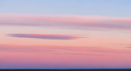 Tranquil and ethereal concept of a blurred sunset sky with soft pastel pink and purple clouds, creating a calm and gentle atmospheric gradient background