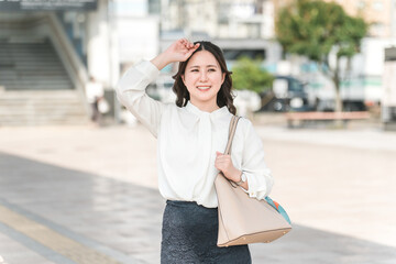 A businesswoman waiting for a bus or taxi at the station to go on a business trip
