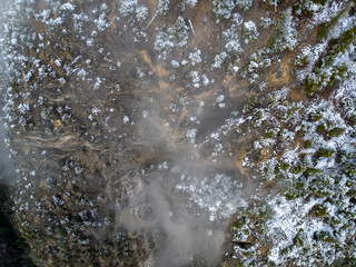 Aerial View Of Snow-Dusted Cliff Face Shrouded In Mist In British Columbia