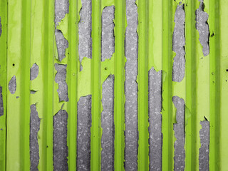 Rusty corrugated sheet with peeling green paint