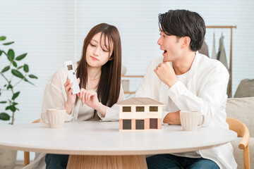 Fototapeta premium A young couple considering their budget for building their own home (over budget, rising prices, housing prices) 