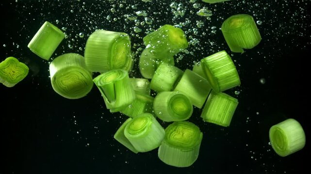 Sliced leeks fall under water. Filmed on a high-speed camera at 1000 fps. High quality FullHD footage