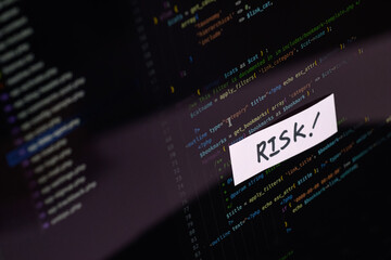 "RISK!" Sticky Note on Programming Code Screen