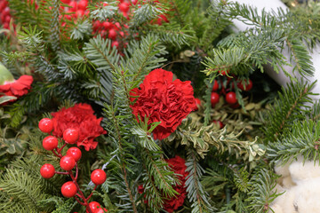 red berries and red carnations on evergreen 