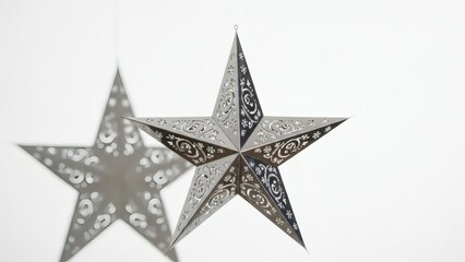 Obraz premium Two decorative star lanterns with intricate cutout patterns on a clean white background