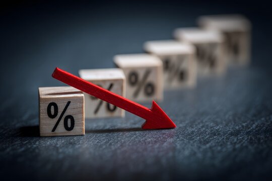 Close-up of small wooden blocks with percentage symbols arranged in a line with a downward red arrow indicating decline or decrease in statistics or rates