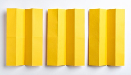 Three yellow folded paper strips on a white background, abstract geometric pattern, minimalist design, creative craft material