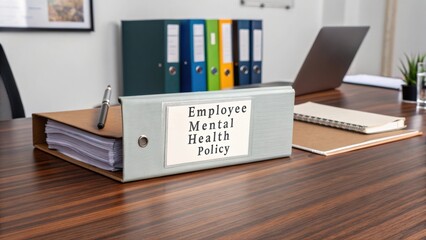 Binder with Employee Mental Health Policy Document on Modern Office Desk Surrounded by Office Supplies and Workspace Items