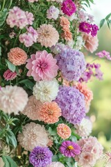 A vibrant arrangement of various blooming flowers including dahlias, hydrangeas, zinnias, and other pink, purple, white, and peach colored flowers creating a lush floral display