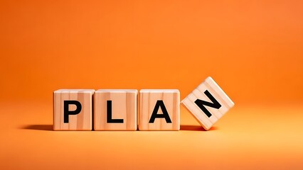 Wooden blocks spelling out the word plan on an orange background