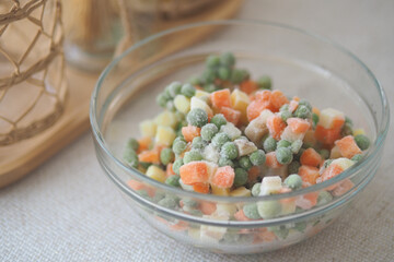 Frozen mixed vegetables in a glass bowl on a table