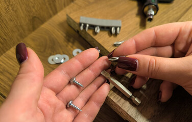 Fototapeta premium Small parts for furniture assembly against a background of wooden panels. Assembling furniture at home and doing home repairs yourself
