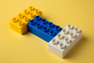 Colorful toy building bricks on yellow background