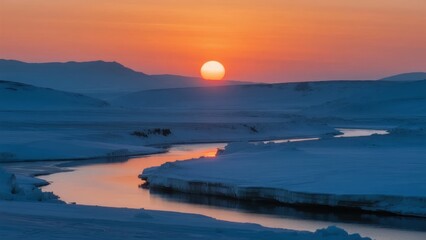 Sunset over a frozen river in a snowy landscape with distant mountains