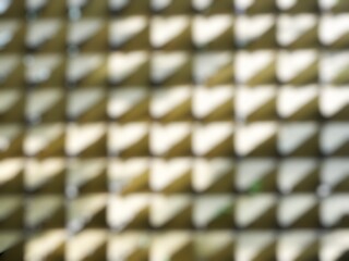 Close-up of a blurred abstract triangle pattern in golden color. Decorative blurred abstract pattern for outdoor wall application.