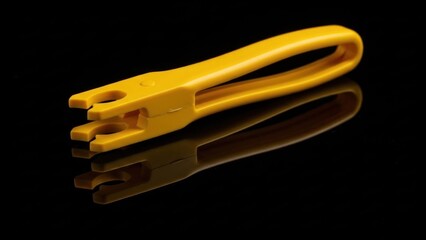 Bright Yellow Plastic Tool on Reflective Black Surface, Studio Shot