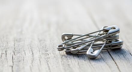 Fototapeta premium Silver safety pins piled on a frosty wooden texture for winter marathon race preparation concept and event day details