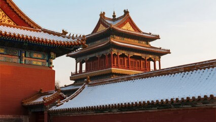 Naklejka premium Traditional Chinese palace architecture with snow-covered rooftops and ornate golden details