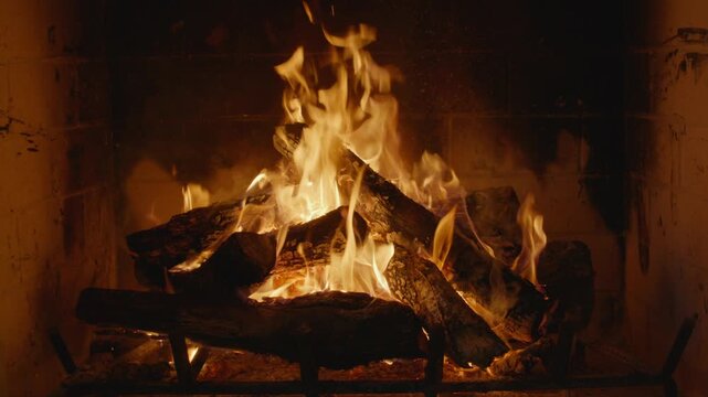 Plate shot of a cozy fireplace with flickering flames and glowing embers providing a warm and inviting atmosphere.