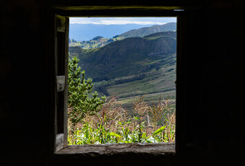 Andean landscape seen through a rustic house window. Andean cornfield in the morning