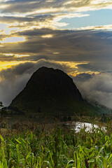 Cloudy landscape of an Andean sunset. Mountain surrounded by mist. Cornfield in the mountains.