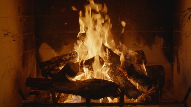 Plate shot of a cozy fireplace scene with burning logs and flickering flames that could be used as a plate shot or background.