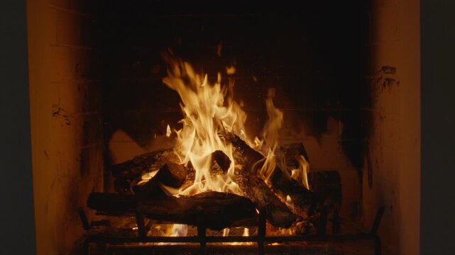 Plate shot of a cozy fireplace with flickering flames and glowing embers creates a warm.