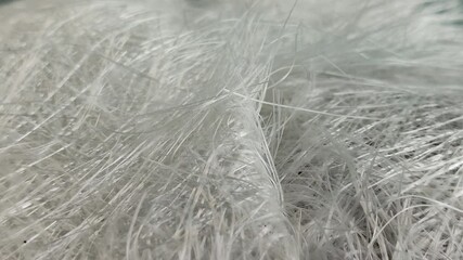 Close up fiberglass stack on a gray background. Fiberglass is a resin reinforced glass fiber composite that is lightweight and strong, corrosion resistant, and a good thermal insulator.