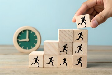 Hand placing block with running figure on top of wooden block staircase
