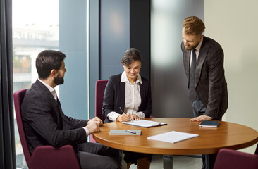Office people, diverse businessmen and businesswoman, client closing successful deal, sitting at table with documents, satisfied hr manager hiring new employee, business partners talking at meeting