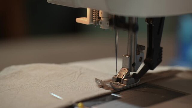 Sewing machine stitching fabric with needle and presser foot close-up