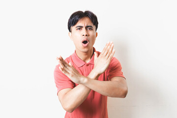 Man making a rejection gesture with both hands, expressing refusal, stop, warning, and defensive body language on a clean background.