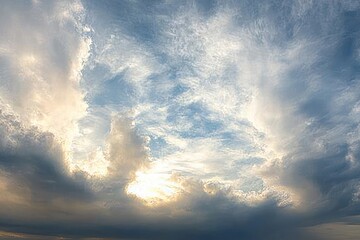 dramatic cloudy sky with sun breaking through layered clouds creating bright and dark contrast
