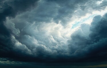 Obraz premium Dramatic dark storm clouds gathering with a bright opening in the center, creating a powerful and moody sky scene