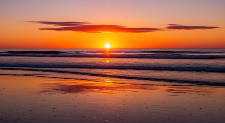 Fototapeta premium Fiery sun descends over gentle ocean waves meeting the wet sand shore