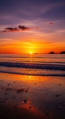 Obraz premium Vivid orange and purple sunset illuminates ocean waves washing over wet sandy shore