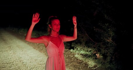 Girl stands with hands up in front of police in dark rural area during tense situation at night