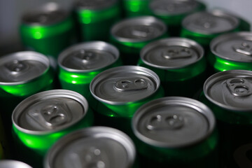 Close up top view of collection of green aluminum beverage cans. group of shiny metal containers creates pattern, representing mass consumption and refreshment
