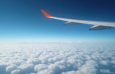 Obraz premium Airplane wing against blue sky over fluffy clouds. Aircraft flies through air above clouds. Travel and aviation concept. Plane wing in flight high above the earth.